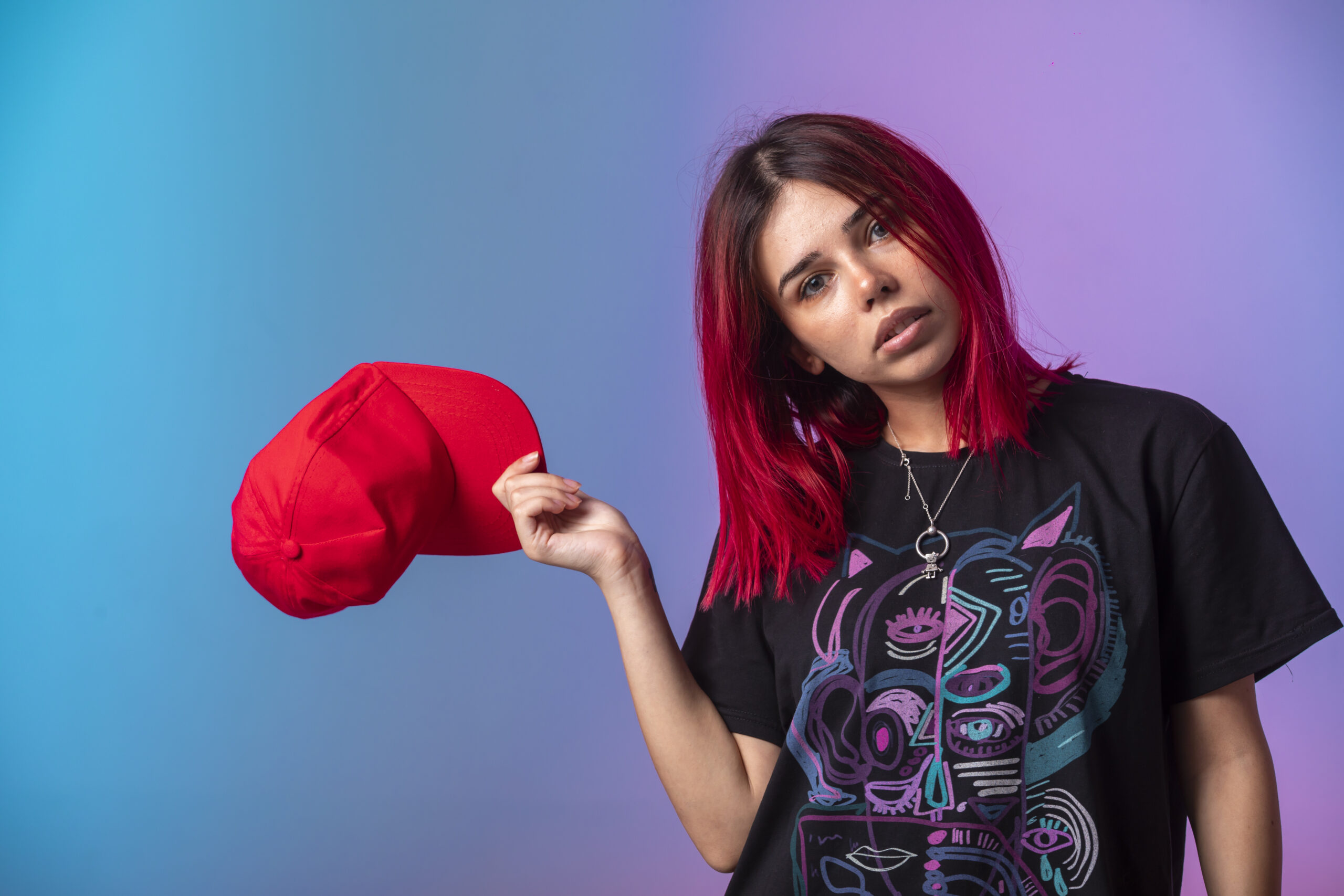 Young girl with pink hairs taking out a red cap